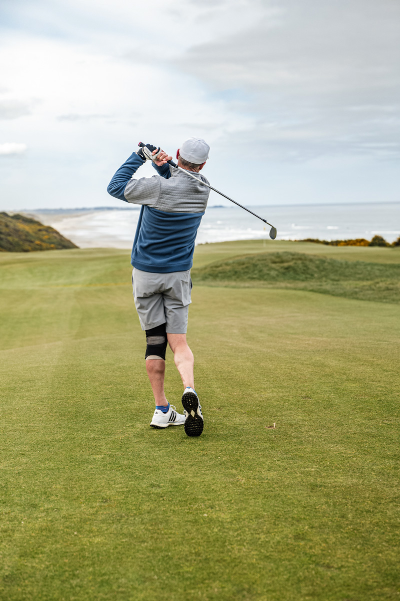 man hitting a golf shot on a golf course