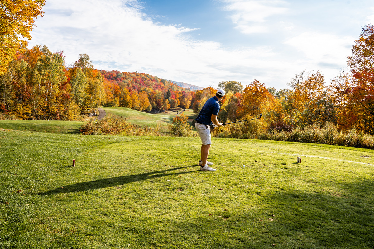 golfer teeing off with beautiful nature